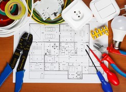 An electrician looks over a blueprint