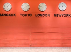 Four time zone clocks on a wall